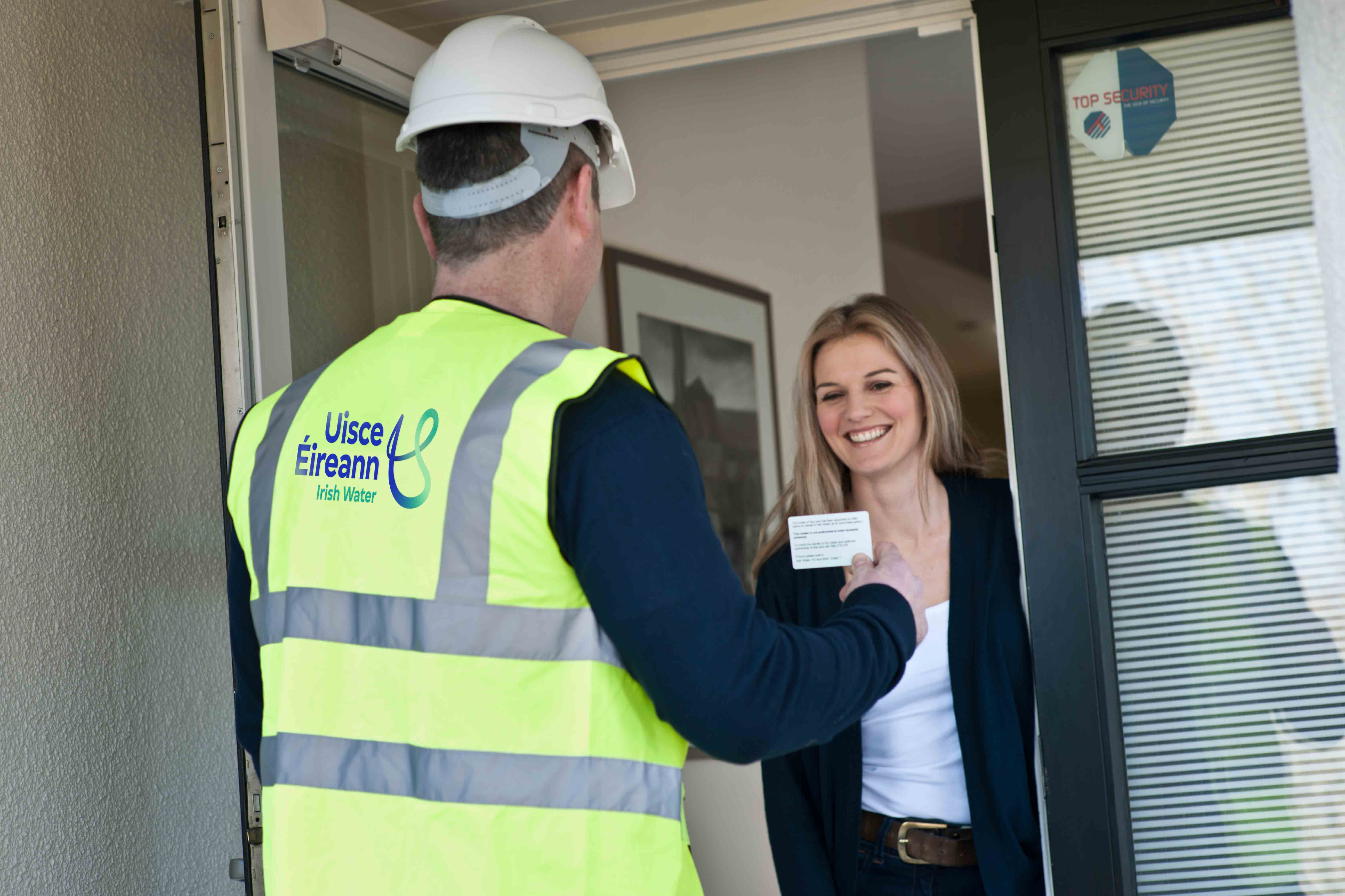 Woman at the door talking to an Uisce Éireann contractor