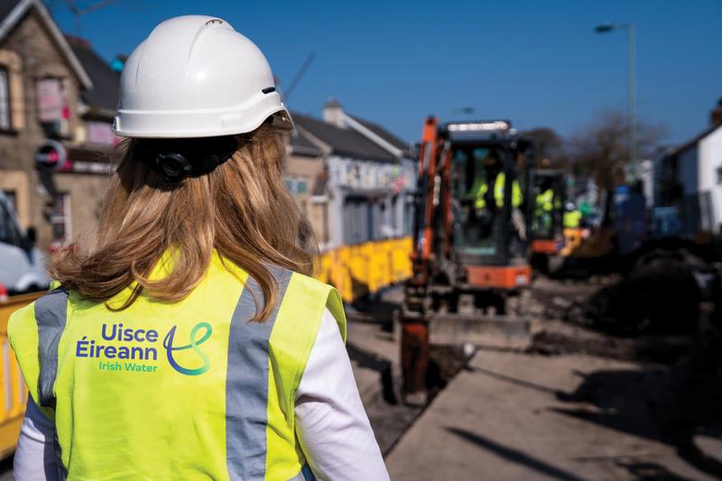 An Uisce Éireann worker on a roadworks site next to a white van