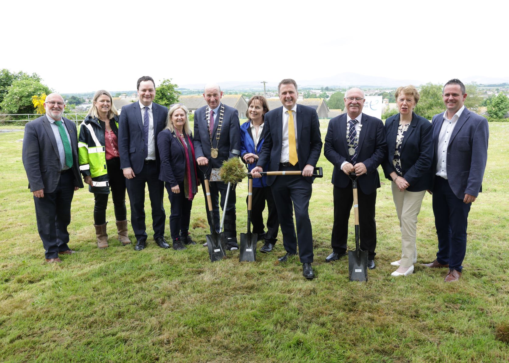 A group of people with shovels smiling at the camera