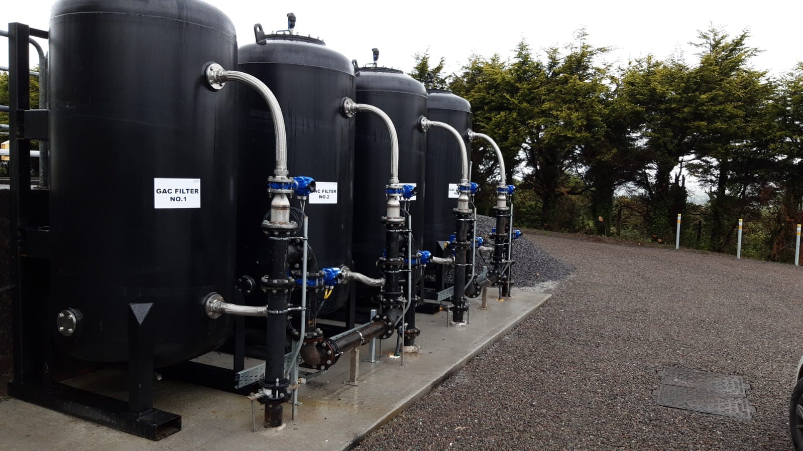 Four black water tanks outside
