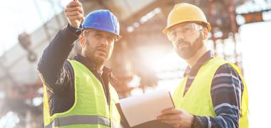 two Uisce Éireann workers pointing at something on site 