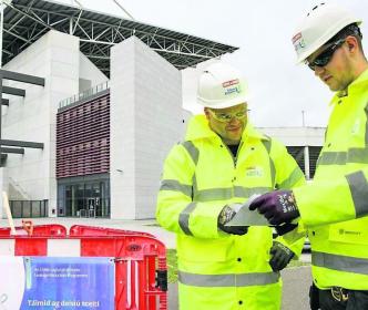 Uisce Éireann workers looking at plans outside a large building in Cork City