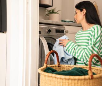 A person putting laundry into a washing machine