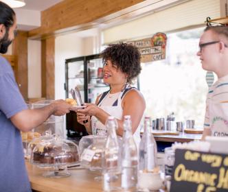 A woman in a cafe serving a customer